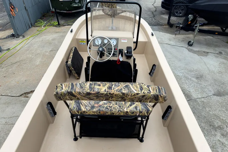 Slide: The Image of 2026 Carolina Skiff E18 JVX CC Sportsman boat interior with camouflage seating and steering console. - 9