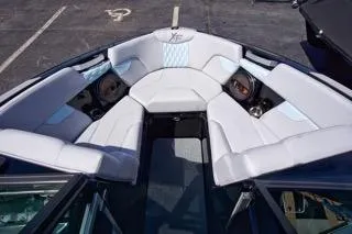 Slide: The Image of 2025 MasterCraft XT22 T boat interior with white seating and integrated speakers. - 11