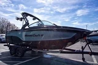 Slide: The Image of 2025 MasterCraft XT22 T boat on trailer under blue sky. - 7