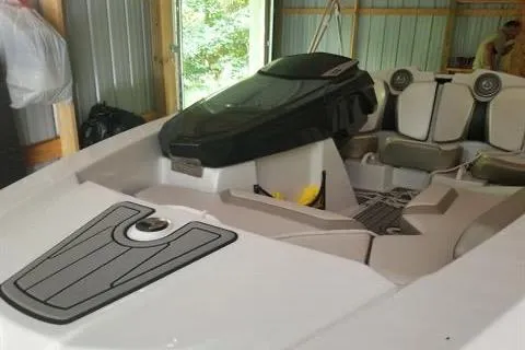 Slide: The Image of 2015 Scarab 165 boat interior in a storage shed, featuring sleek seating and controls. - 11