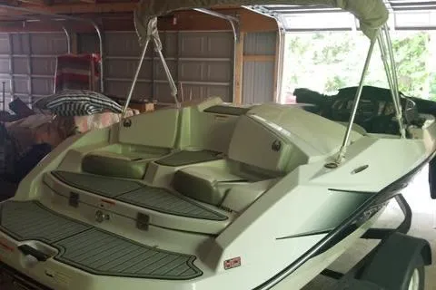 Slide: The Image of 2015 Scarab 165 boat in a garage, featuring a sleek design and comfortable seating. - 12