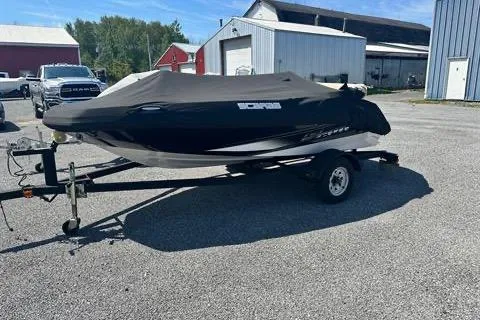 Slide: The Image of 2015 Scarab 165 boat on trailer, covered, parked in a rural setting. - 4