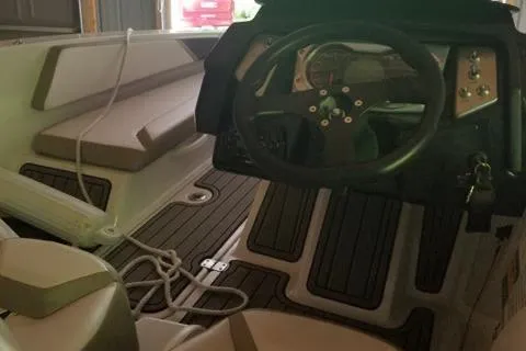 Slide: The Image of Interior of a 2015 Scarab 165 boat with steering wheel and seating. - 5
