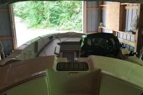 Slide: The Image of 2015 Scarab 165 boat interior in a garage, featuring steering console and seating. - 6