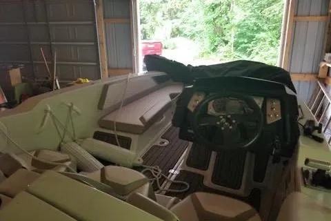 Slide: The Image of 2015 Scarab 165 boat interior in garage, featuring steering wheel and seating. - 7