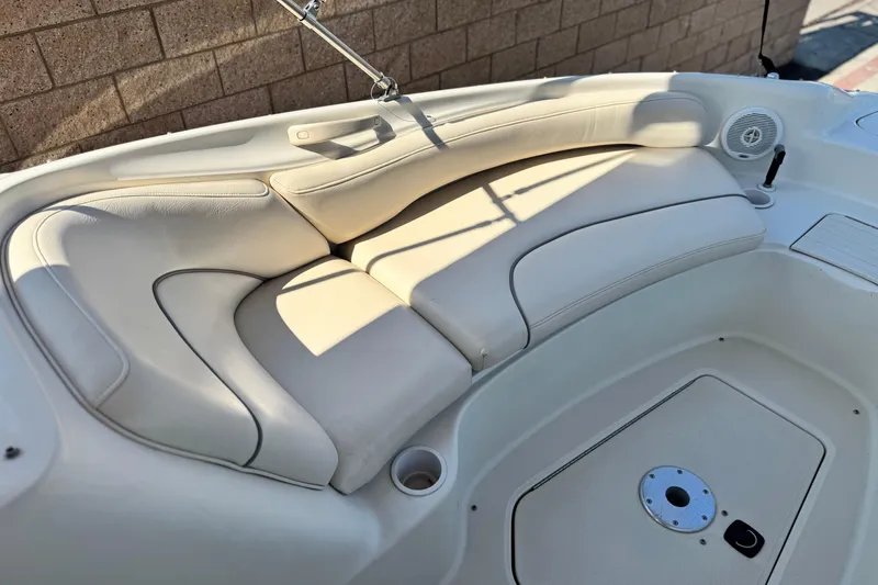 Slide: The Image of Interior seating of a 2000 Sea Ray 240 Sundeck boat, featuring beige upholstery. - 10
