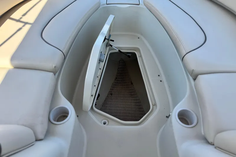 Slide: The Image of Open storage compartment on 2000 Sea Ray 240 Sundeck boat with cup holders. - 12