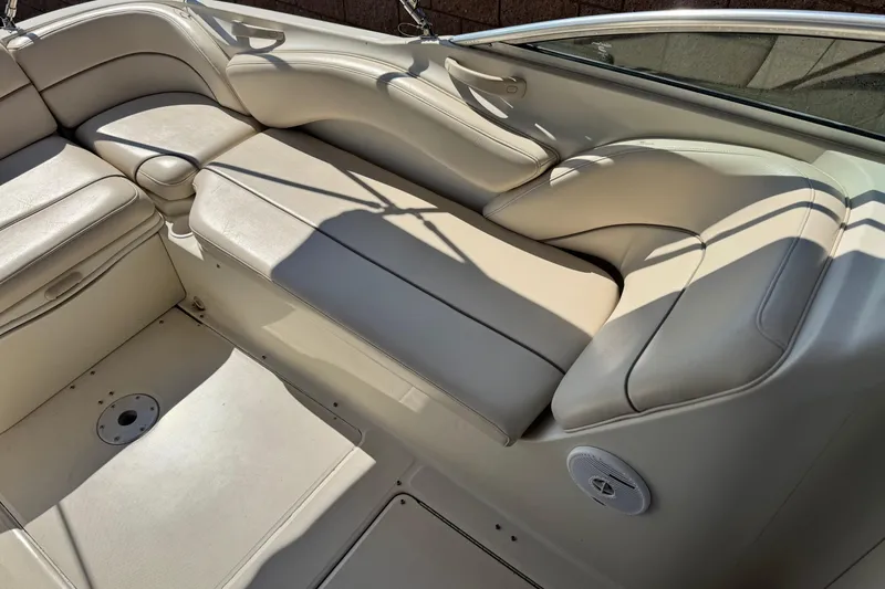 Slide: The Image of Interior seating of a 2000 Sea Ray 240 Sundeck boat, featuring beige upholstery. - 19