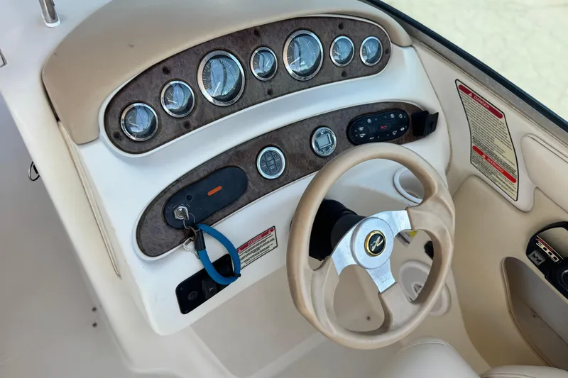 Slide: The Image of 2000 Sea Ray 240 Sundeck dashboard with gauges and steering wheel. - 27