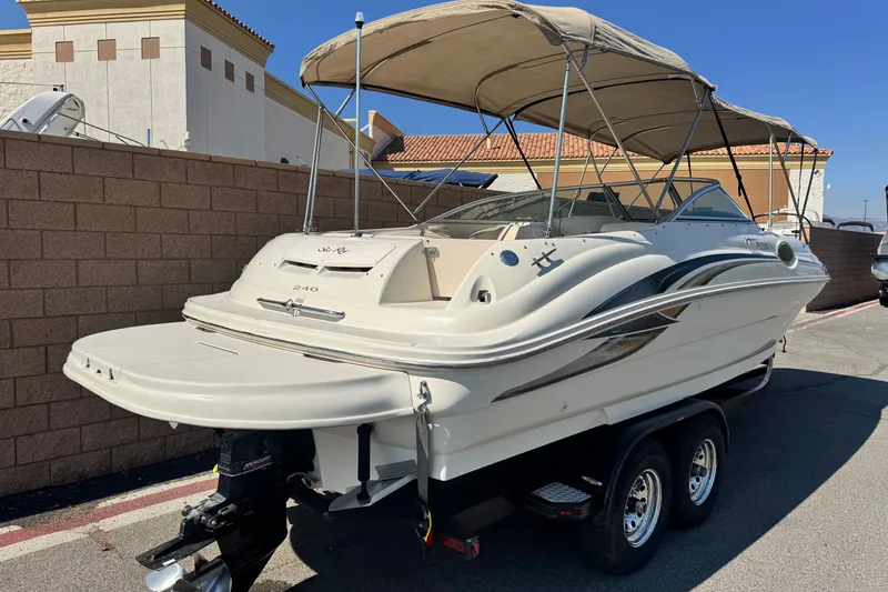 Slide: The Image of 2000 Sea Ray 240 Sundeck boat on trailer, parked outdoors with canopy. - 5
