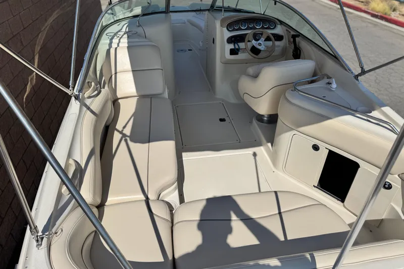 Slide: The Image of 2000 Sea Ray 240 Sundeck interior with beige seating and steering console. - 8