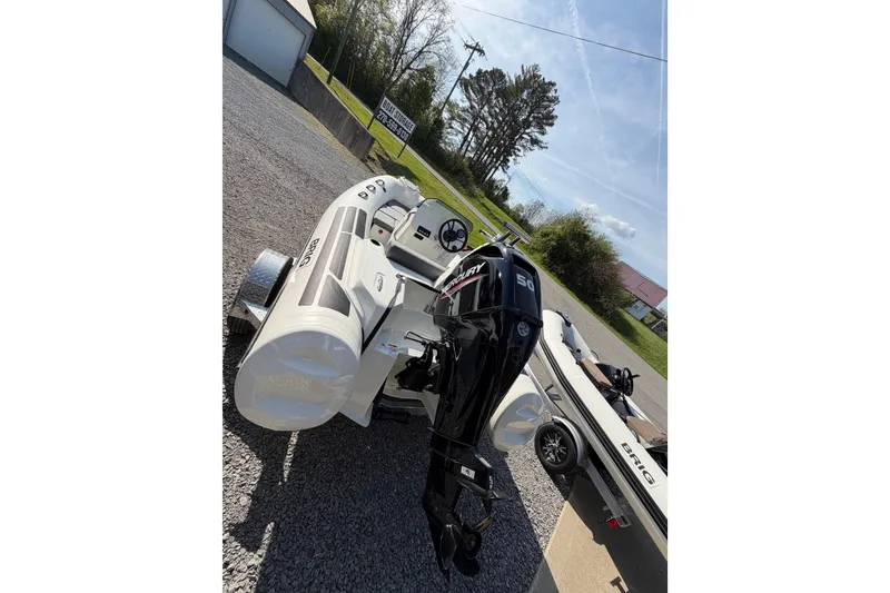 Slide: The Image of 2026 Brig Eagle 4 inflatable boat with Mercury 50 engine on trailer, outdoor setting. - 7