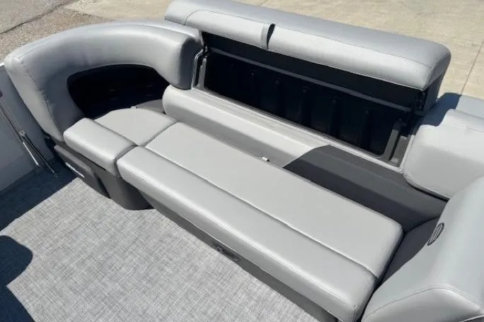 Slide: The Image of 2025 Sun Tracker Party Barge 20 DLX with spacious gray seating and storage compartment. - 11