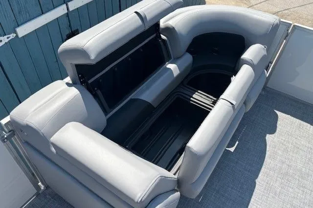 Slide: The Image of 2025 Sun Tracker Party Barge 20 DLX with open storage compartment and gray seating. - 14