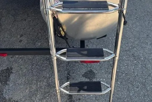 Slide: The Image of 2025 Sun Tracker Party Barge 20 DLX ladder on asphalt surface. - 29