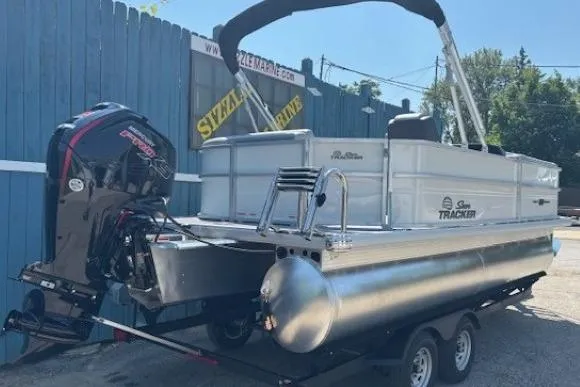 Slide: The Image of 2025 Sun Tracker Party Barge 20 DLX pontoon boat on trailer, outdoor setting. - 3