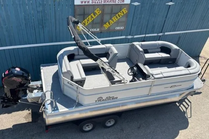 Slide: The Image of 2025 Sun Tracker Party Barge 20 DLX pontoon boat on trailer, parked outdoors. - 8