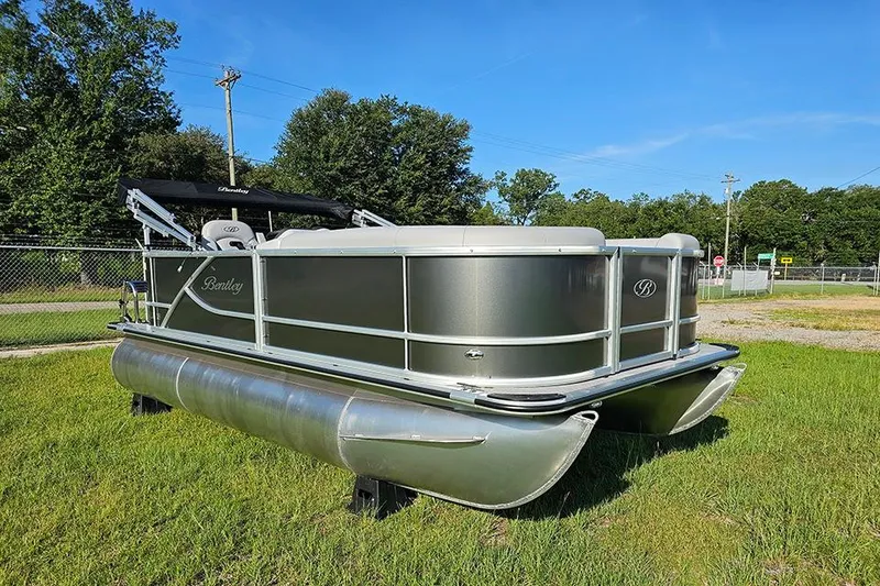 Slide: The Image of 2026 Bentley Pontoons LE 180 Cruise with Mercury outboard, covered and parked outdoors. - 2