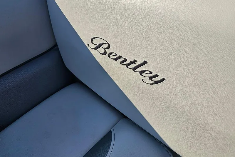 Slide: The Image of 2026 Bentley Pontoons LE 180 Cruise interior with gray seating and storage compartments. - 23