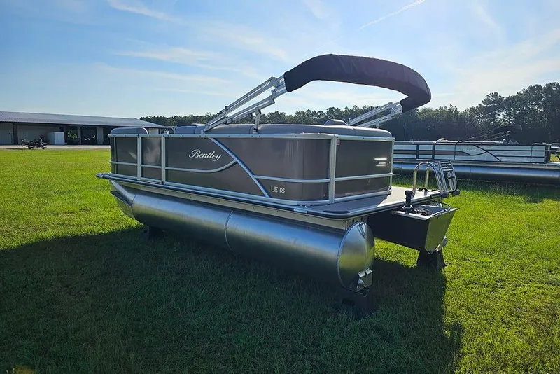 Slide: The Image of 2026 Bentley Pontoons LE 180 Cruise pontoon boat on grassy field, side view. - 7