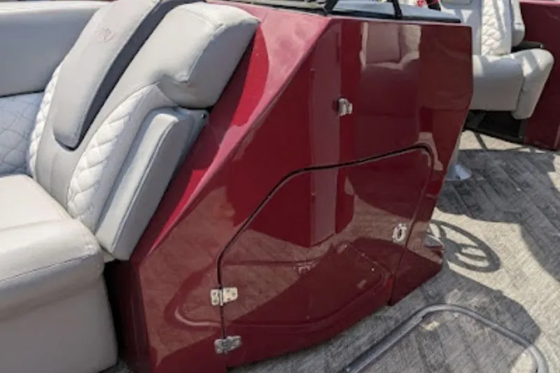 Slide: The Image of 2019 Manitou Legacy 25 RFXW boat interior with red console and gray seating. - 12