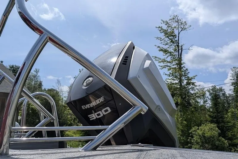 Slide: The Image of 2019 Manitou Legacy 25 RFXW with Evinrude 300 engine, surrounded by trees. - 20