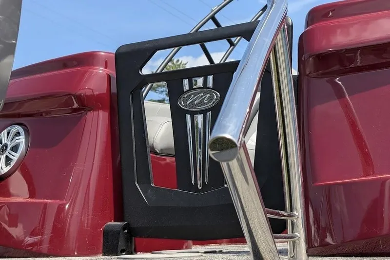 Slide: The Image of 2019 Manitou Legacy 25 RFXW boat, red exterior, chrome railing, and speaker detail. - 27