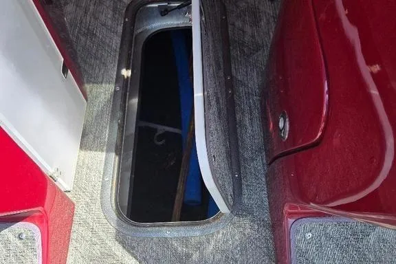 Slide: The Image of 2019 Manitou Legacy 25 RFXW boat interior with open storage compartment. - 4