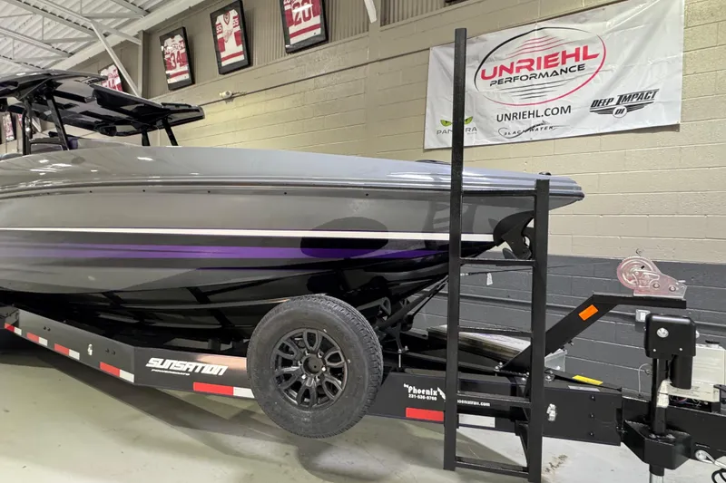 Slide: The Image of 2026 Sunsation 32 CCX boat on trailer in showroom with performance branding. - 5