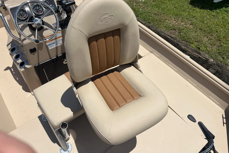 Slide: The Image of 2025 G3 Bay 17 boat interior with beige and brown captain's seat, steering console visible. - 11