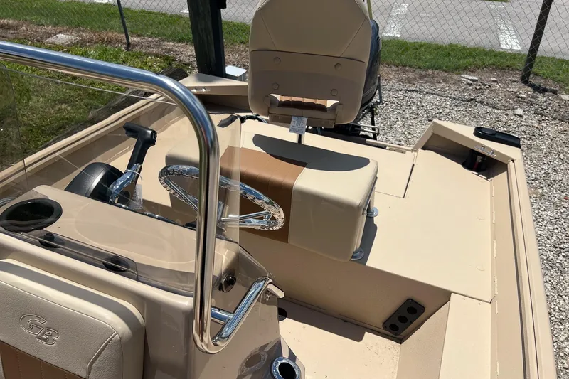 Slide: The Image of 2025 G3 Bay 17 boat interior with steering wheel and seating, parked on gravel. - 9