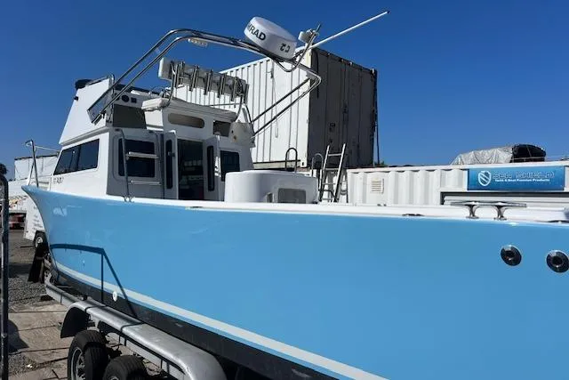 Slide: The Image of 1971 Mariners BAJA 30 boat with blue hull, docked outdoors, featuring radar equipment. - 12
