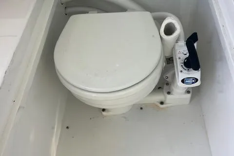 Slide: The Image of 1971 Mariners BAJA 30 marine toilet with manual pump in white compartment. - 15