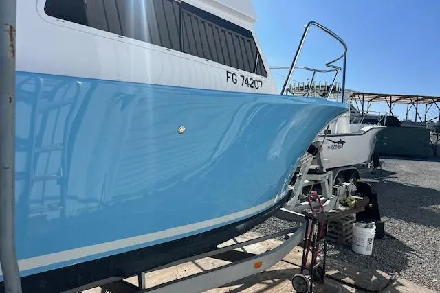 Slide: The Image of Blue 1971 Mariners BAJA 30 boat on trailer in sunny boatyard. - 4
