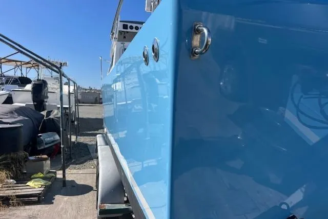 Slide: The Image of 1971 Mariners BAJA 30 boat with blue hull, parked outdoors on a sunny day. - 8