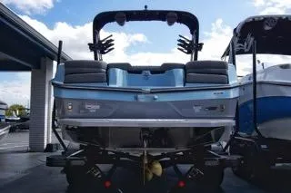 Slide: The Image of 2025 MasterCraft XT22 T boat, rear view, parked at a marina. - 4