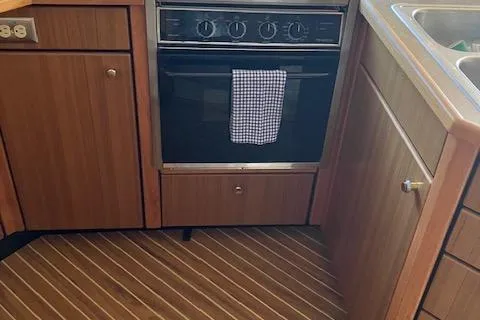 Slide: The Image of 2001 Bayliner 3988 Motoryacht kitchen with oven, wooden cabinets, and striped flooring. - 13