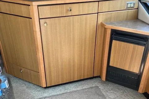 Slide: The Image of 2001 Bayliner 3988 Motoryacht interior with wooden cabinetry and compact fridge. - 19