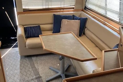 Slide: The Image of 2001 Bayliner 3988 Motoryacht interior with beige seating, blue cushions, and a wooden table. - 21