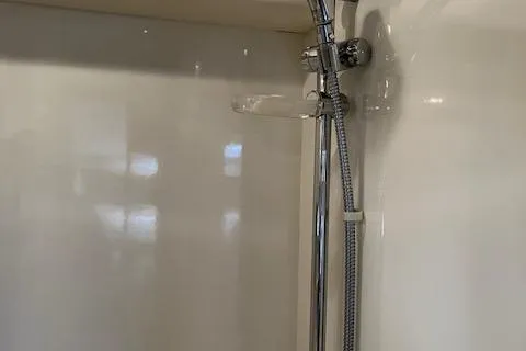 Slide: The Image of 2001 Bayliner 3988 Motoryacht shower with chrome fixtures and white interior. - 33