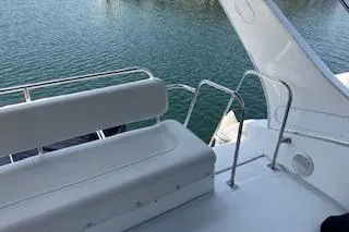 Slide: The Image of 2001 Bayliner 3988 Motoryacht deck with white seating and railing, overlooking water. - 48