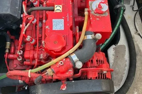 Slide: The Image of Red engine of a 2001 Bayliner 3988 Motoryacht, showcasing intricate components and hoses. - 70