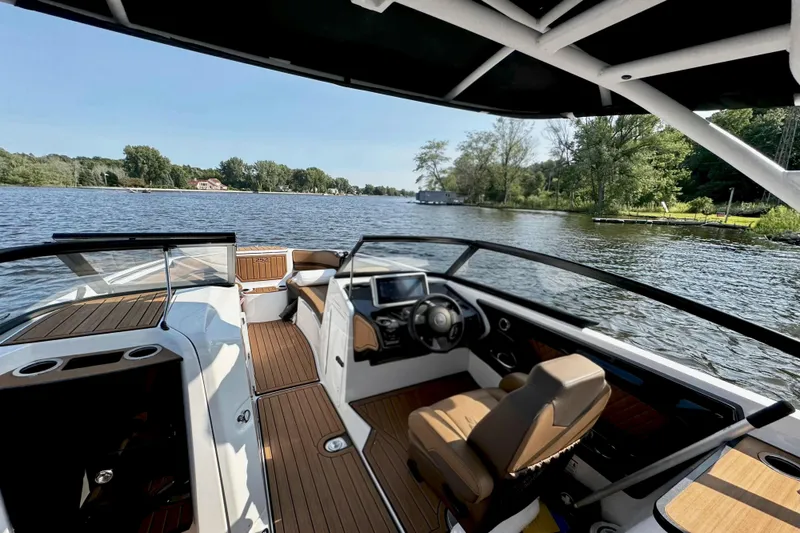 Slide: The Image of 2024 Yamaha Boats 252SE interior with sleek design on a serene lake. - 2