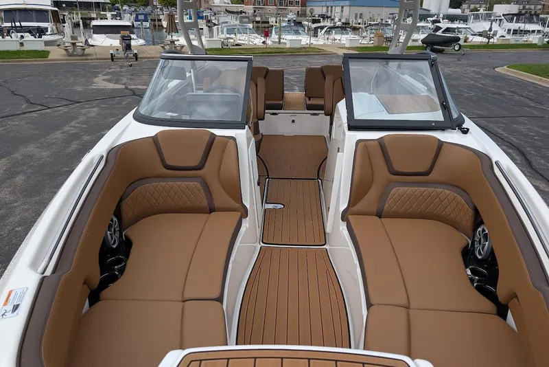 Slide: The Image of 2024 Yamaha Boats 252SE interior with tan seating and sleek design at marina. - 32