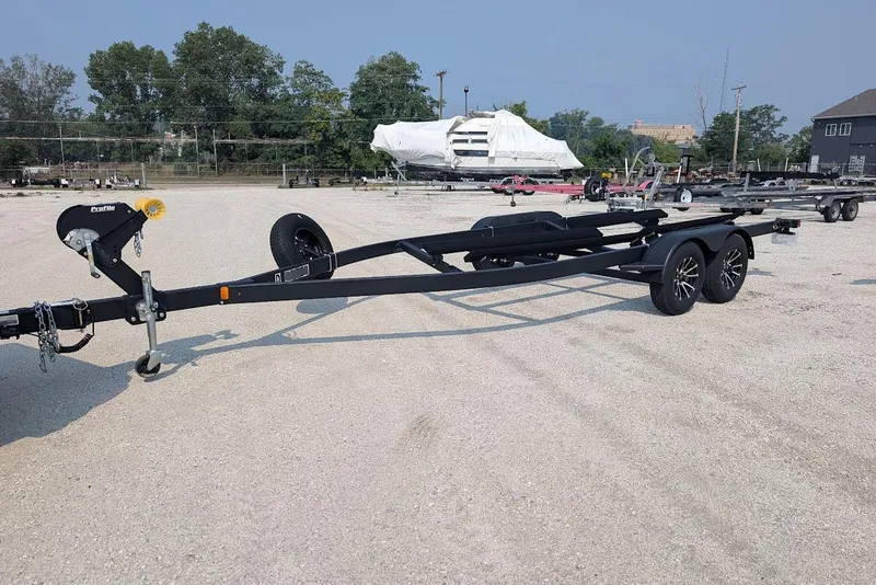 Slide: The Image of Trailer for 2024 Yamaha Boats 252SE, parked in a gravel lot with trees in the background. - 41