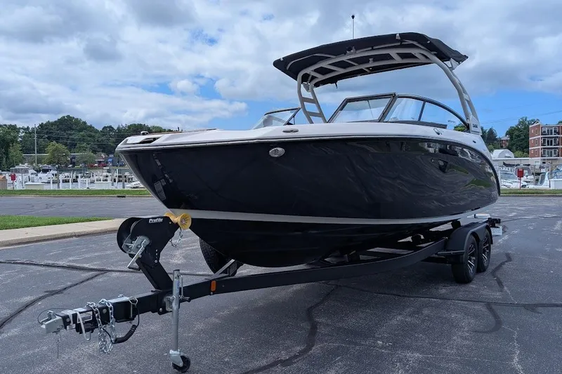 Slide: The Image of 2024 Yamaha Boats 252SE on trailer, sleek black design, parked outdoors. - 8