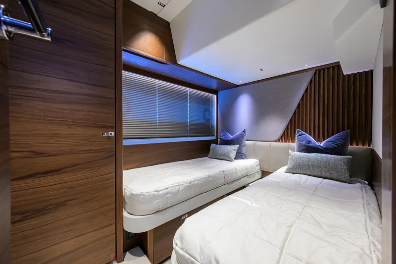 Slide: The Image of Luxurious 2026 Princess S72 yacht cabin with twin beds and modern wood paneling. - 27