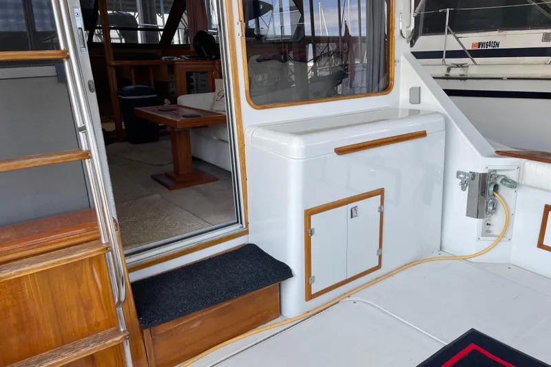 Slide: The Image of 1988 Chris-Craft 392 Sport Fish boat interior with wooden accents and seating area. - 16