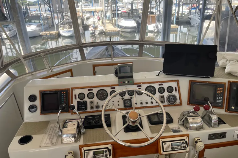 Slide: The Image of 1988 Chris-Craft 392 Sport Fish helm with gauges, controls, and marina view. - 2