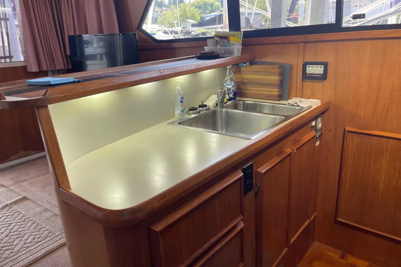 Slide: The Image of 1988 Chris-Craft 392 Sport Fish yacht interior with wooden cabinetry and sink area. - 26